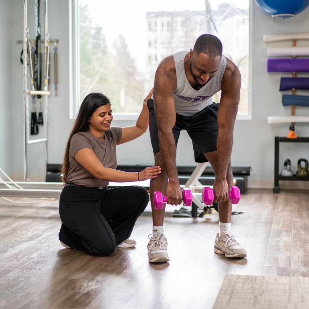 A therapist shows a patient how to perform a leg exercise