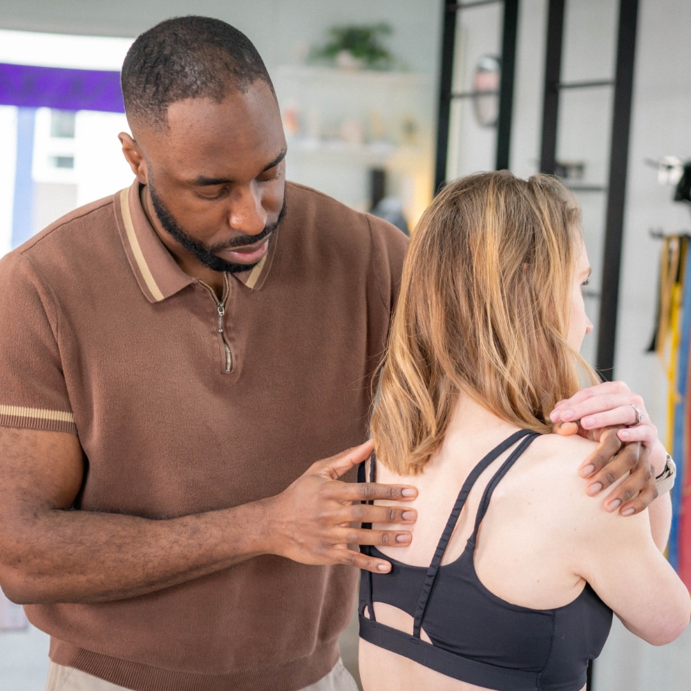 A therapist helps a patient with spinal alignment