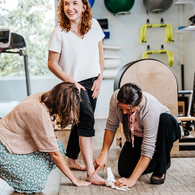 clinicians compare model foot bones to patient's foot