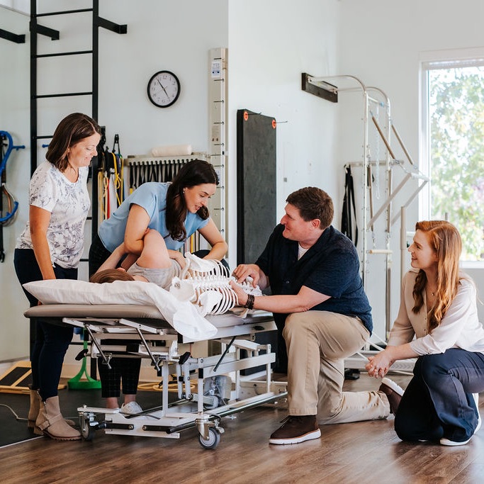 clinicians work with patient on a table